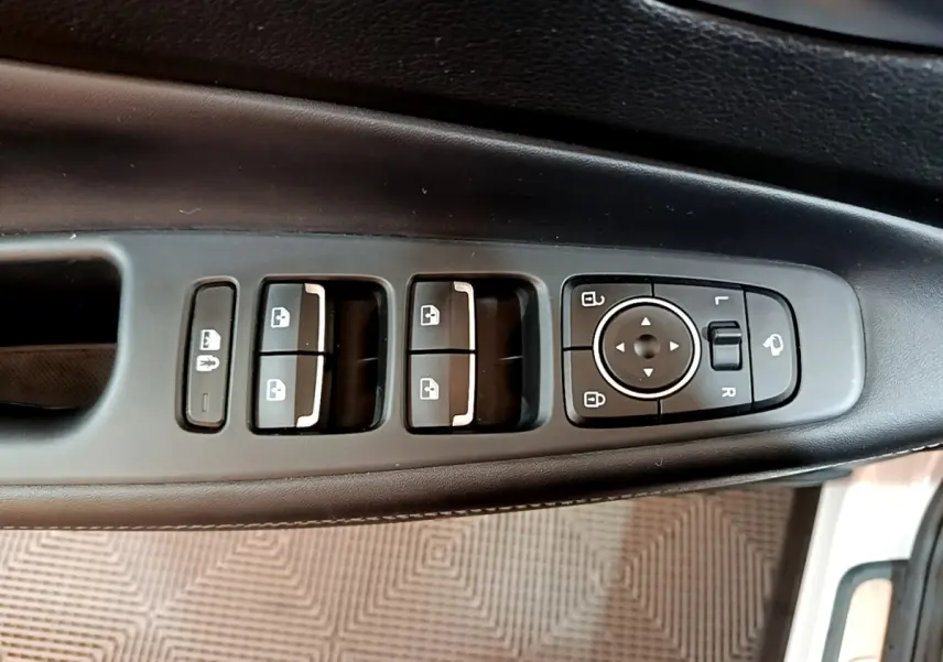 Panneau de commandes des vitres et rétroviseurs côté conducteur du Hyundai Santa Fe blanc, intérieur noir.