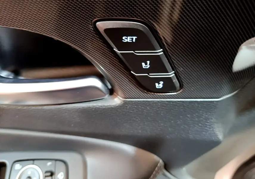 Gros plan sur les boutons de réglage mémoire des sièges noirs dans l'habitacle du Hyundai Santa Fe blanc 2022.