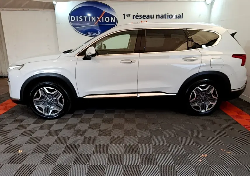 Vue latérale droite d'un Hyundai Santa Fe blanc 2022, SUV hybride avec jantes alliage et vitres teintées.