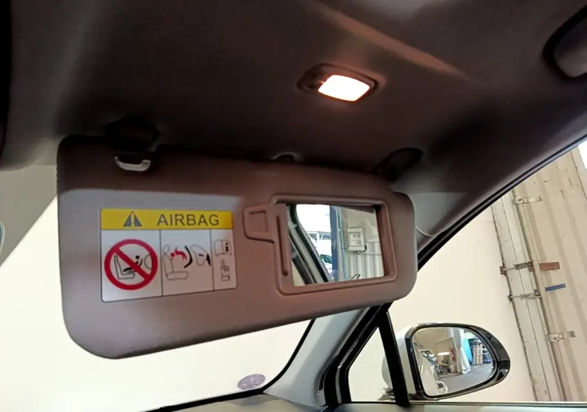 Détail du pare-soleil côté conducteur avec miroir et avertissement airbag dans un Hyundai Santa Fe blanc 2022.