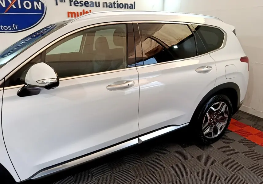 Profil côté gauche du Hyundai Santa Fe blanc 2022, avec jantes alliage et rétroviseur blanc brillant.