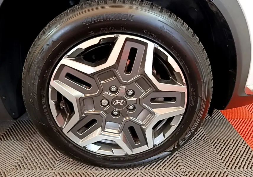Gros plan sur la roue avant droite du Hyundai Santa Fe blanc 2022 avec jante alliage et pneu Hankook.