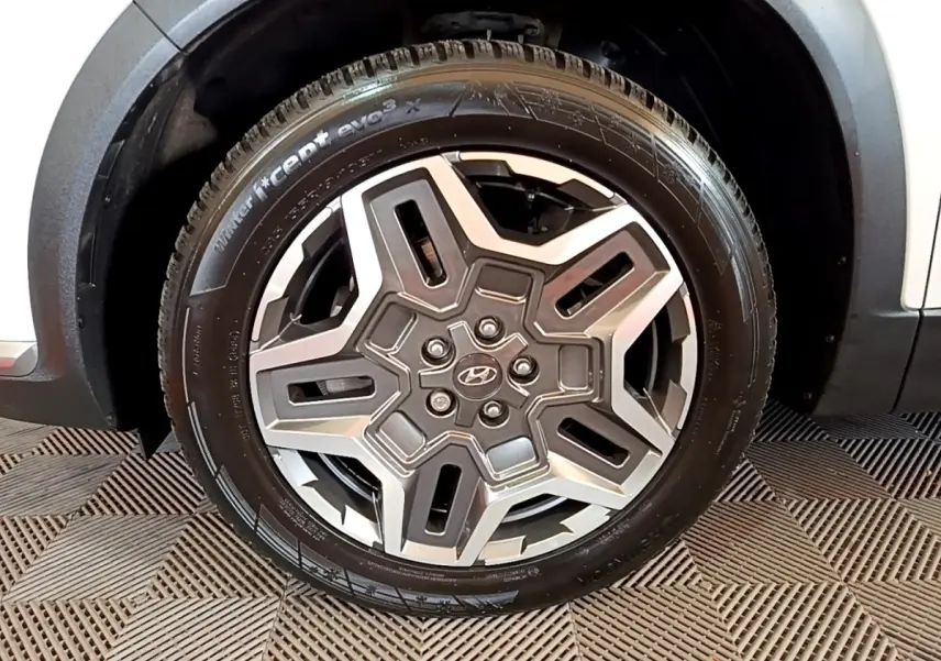 Gros plan sur la roue avant droite du Hyundai Santa Fe blanc 2022 avec jante alliage au design moderne.