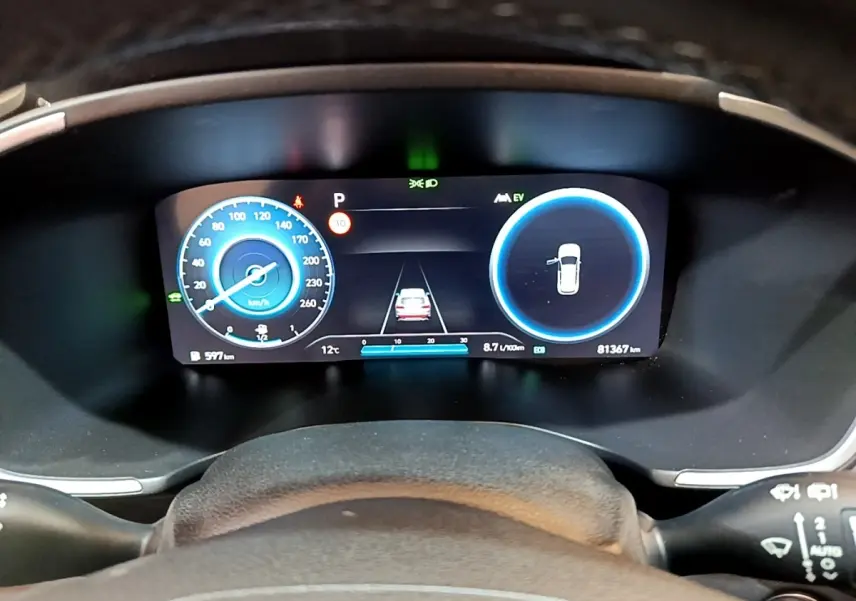 Affichage numérique du tableau de bord du Hyundai Santa Fe hybride 2022, avec vitesse, autonomie et aide au stationnement.