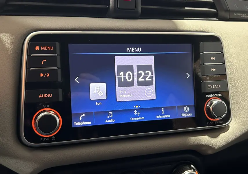 Écran tactile central de la Nissan Micra 2021, vue frontale du tableau de bord avec commandes audio et menu affiché.