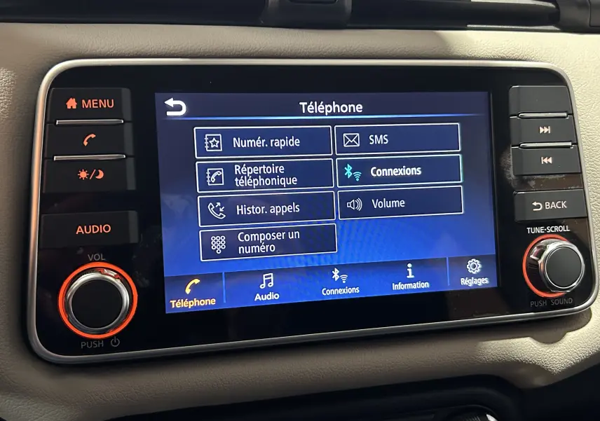 Écran tactile central de la Nissan Micra 2021 blanc, affichant le menu téléphone avec options de connexion Bluetooth.