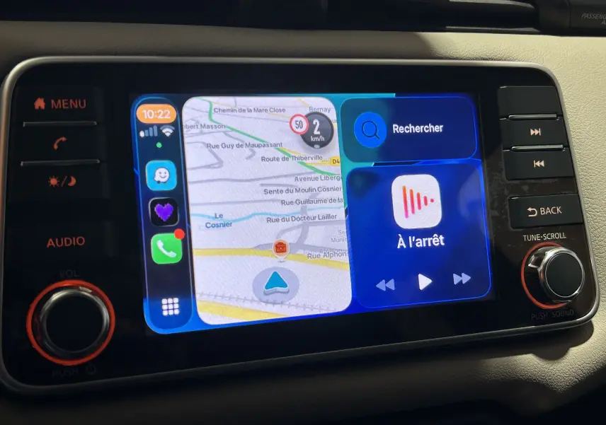 Écran tactile central de la Nissan Micra 2021 affichant la navigation et les commandes multimédia, entouré de boutons noirs.