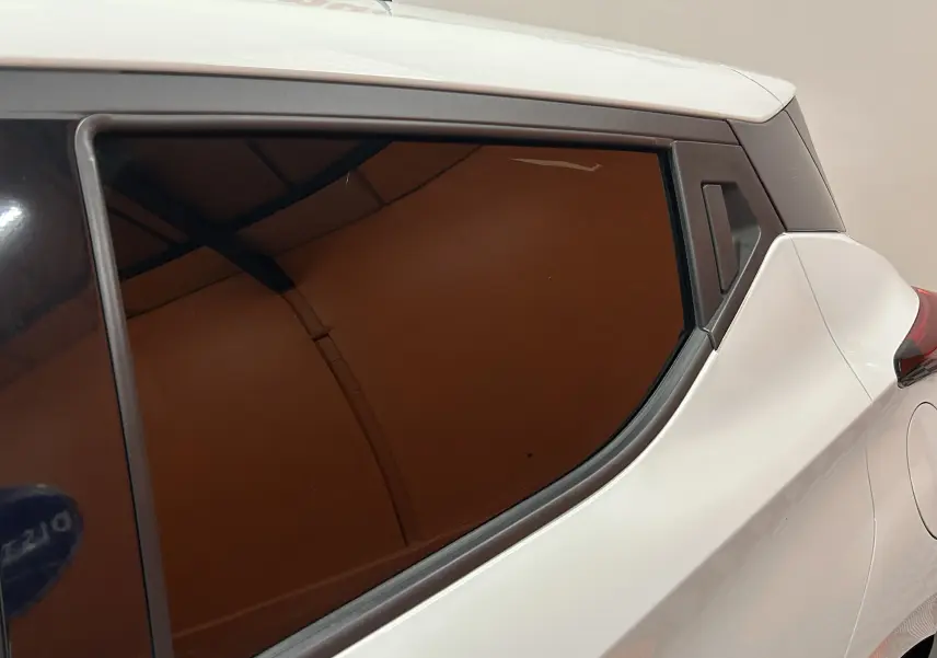 Détail de la vitre arrière teintée côté droit d'une Nissan Micra blanche 2021 avec carrosserie lisse.