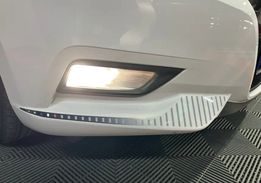 Gros plan sur l'antibrouillard avant droit blanc d'une Nissan Micra 2021 avec un détail graphique rayé noir et blanc.