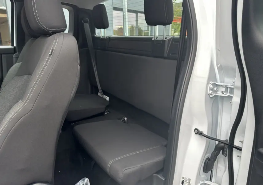 Vue intérieure côté droit du Ford Ranger blanc glacier 2026, montrant les sièges arrière rabattus et la porte ouverte.