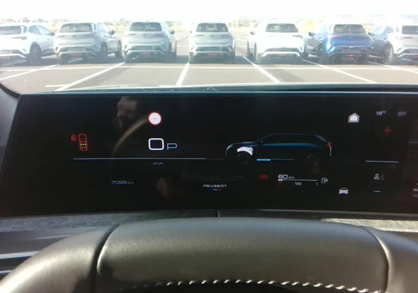 Vue intérieure du tableau de bord numérique du Peugeot 5008 Hybrid 2025, affichant l'interface de conduite et l'autonomie électrique.