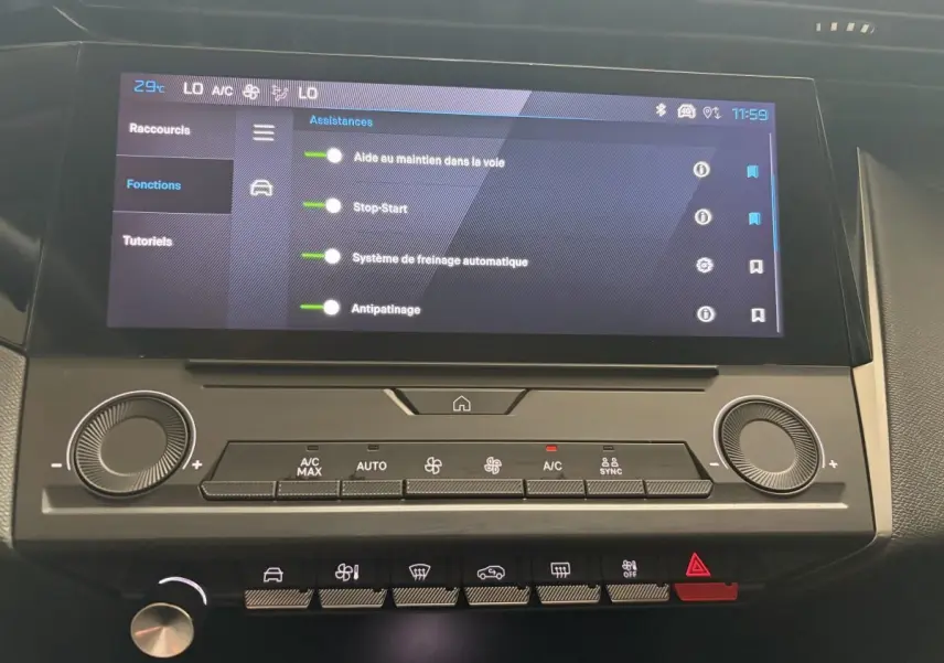 Gros plan sur l'écran tactile central et les commandes de climatisation de la Peugeot 308 blanche de 2024.
