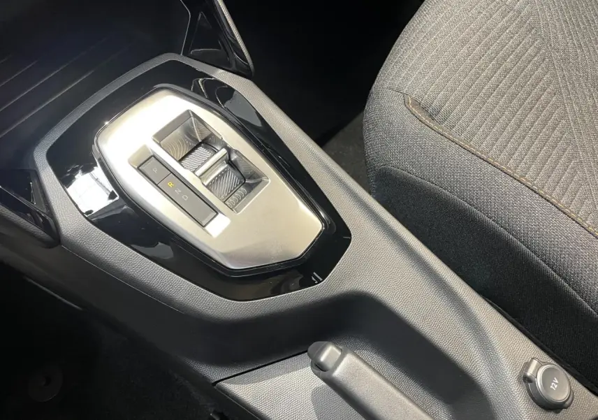 Gros plan sur la console centrale du Peugeot 2008 blanc, montrant la boîte automatique et le frein à main manuel.