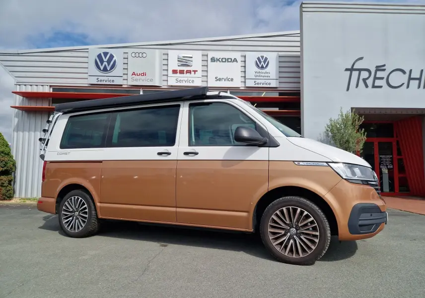 Vue latérale droite d'un Volkswagen California 2.0 TDi Cooper bronze avec toit relevable et jantes alliage.