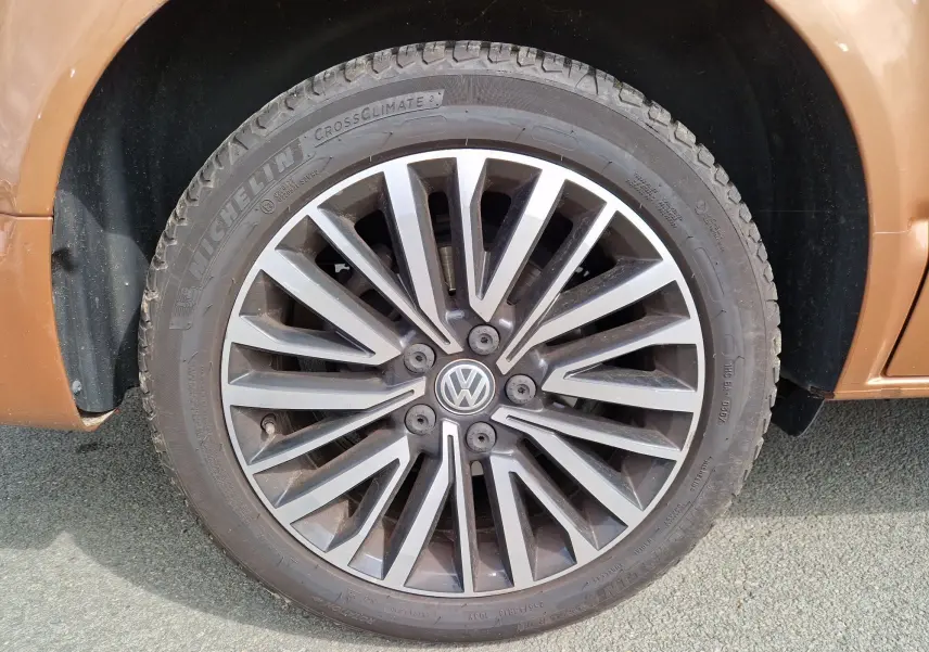 Gros plan sur la roue avant gauche en alliage du Volkswagen California Cooper bronze 2021, soulignant le design moderne.