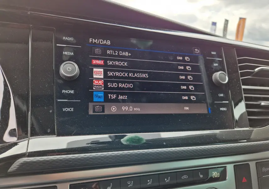 Écran multimédia du tableau de bord du Volkswagen California 2021 affichant les stations FM et DAB.