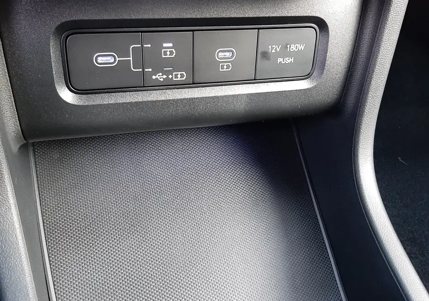 Prise USB-C et port 12V dans la console centrale du Hyundai Tucson 2025 finition Executive en intérieur noir.