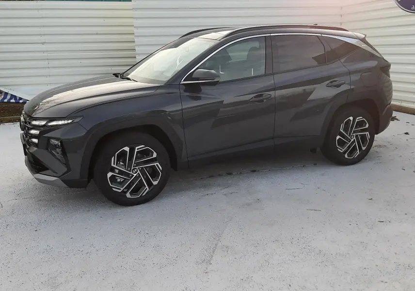Hyundai Tucson 2025 gris Ecotronic vu de profil côté gauche, avec jantes alliage 19" et toit panoramique.