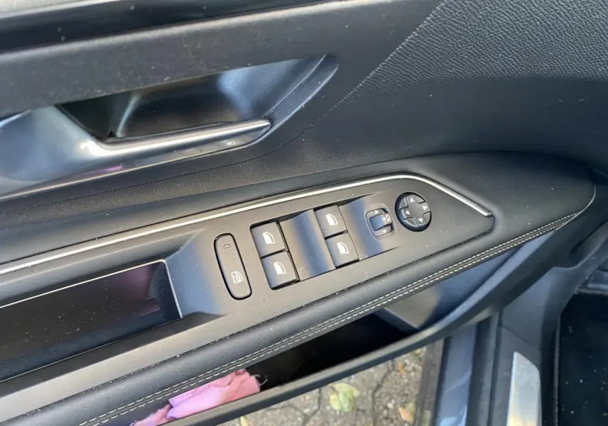 Commande des vitres et rétroviseurs côté conducteur du Peugeot 3008 gris foncé, intérieur noir avec surpiqûres blanches.