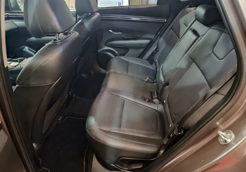 Vue intérieure côté droit sur les sièges arrière en cuir noir du Hyundai Tucson marron 2022 hybride rechargeable.