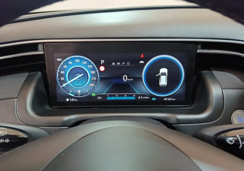 Tableau de bord numérique du Hyundai Tucson 2022, affichage 10,3 pouces avec indicateurs vitesse et porte ouverte.