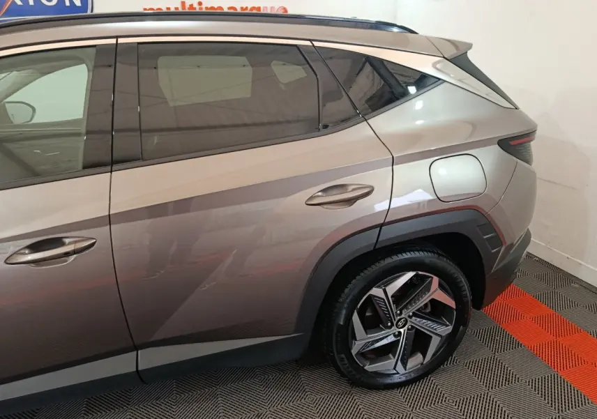 Vue latérale droite du Hyundai Tucson marron 2022, mettant en valeur la portière arrière et la jante au design moderne.