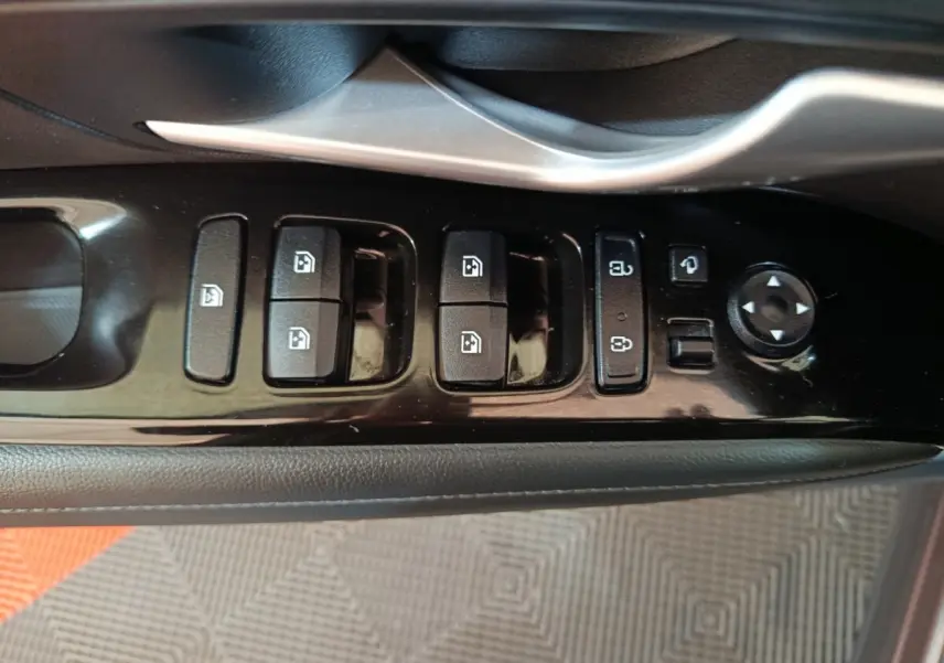 Vue rapprochée du panneau de commandes des vitres et rétroviseurs côté conducteur du Hyundai Tucson marron 2022.
