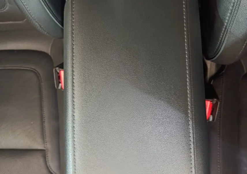 Vue plongeante sur l'accoudoir central en cuir noir entre les sièges avant du Hyundai Tucson marron 2022.