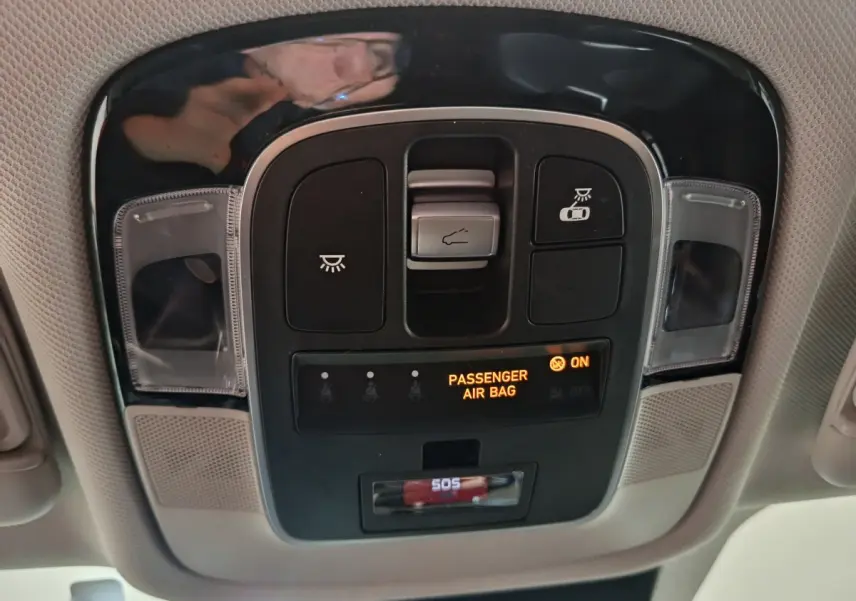 Vue en gros plan du panneau de commandes au plafond avec indicateur airbag passager allumé dans un Hyundai Tucson 2022 marron.