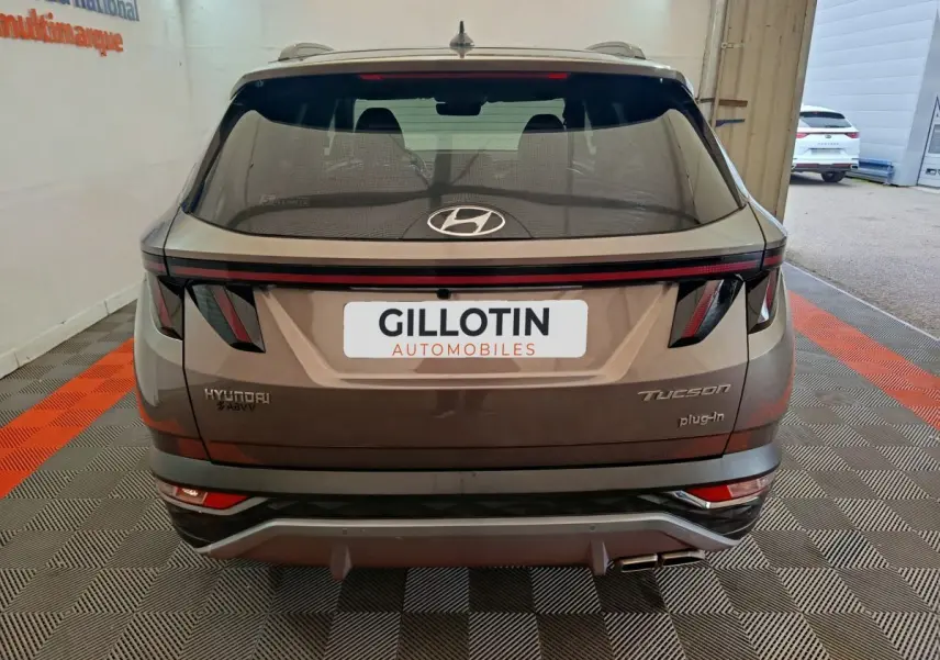 Vue arrière du Hyundai Tucson marron 2022 avec feux LED et logo plug-in hybride visible sur le hayon.