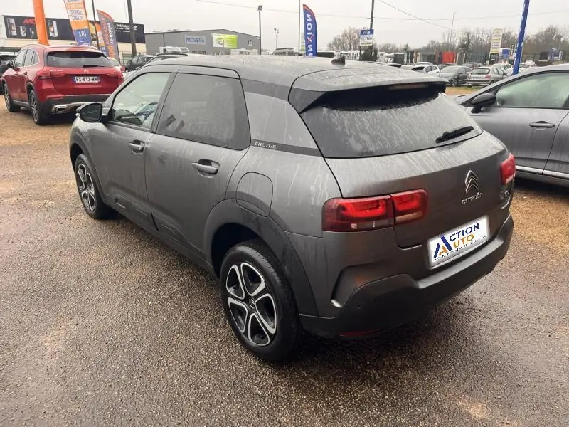 Vue 3/4 arrière droite d'une Citroën C4 Cactus gris Platinium avec jantes originales et logo Cactus sur l'aile arrière.