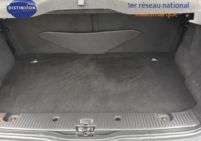 Coffre ouvert de Renault Twingo III gris foncé, vue de l'arrière montrant l'espace de chargement vide et la moquette noire.