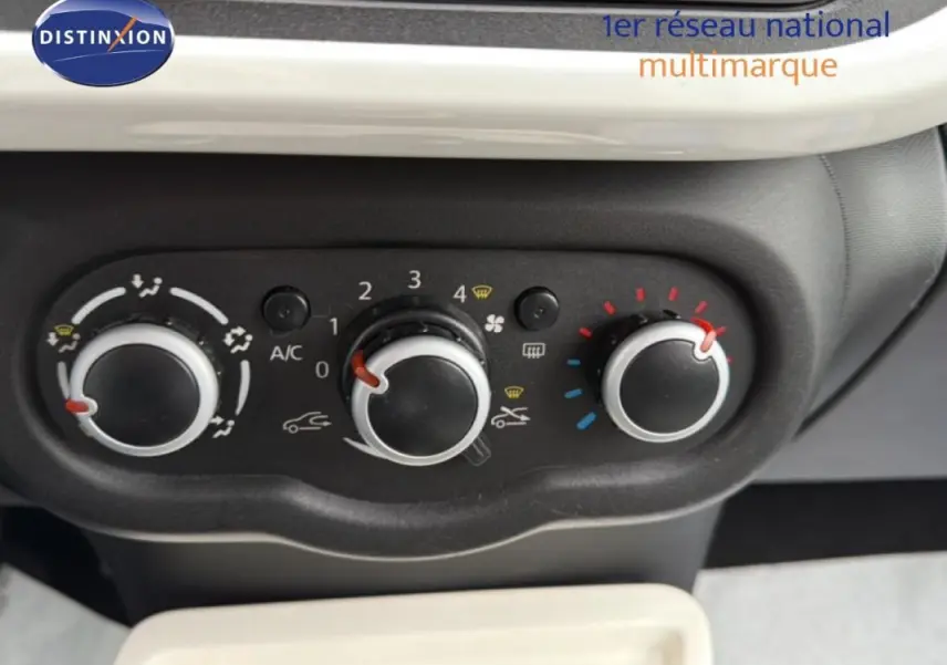 Vue rapprochée des commandes de climatisation manuelle sur tableau de bord noir de Renault Twingo gris foncé.