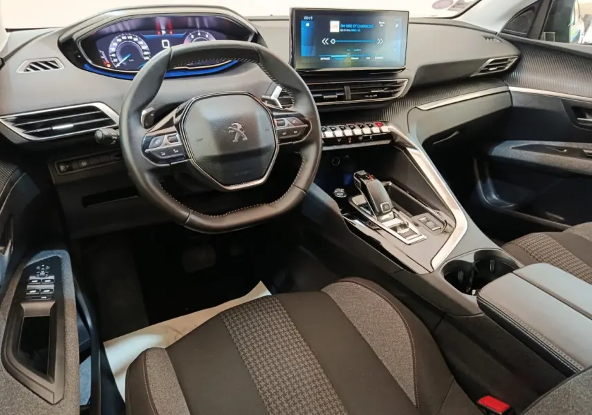Intérieur Peugeot 3008 2022 vu côté conducteur, volant cuir, tableau de bord digital et écran tactile central.
