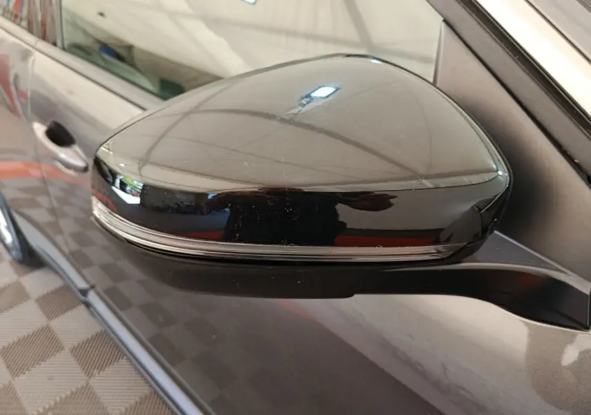 Rétroviseur droit noir brillant avec clignotant intégré sur Peugeot 3008 gris foncé, vue rapprochée côté passager.