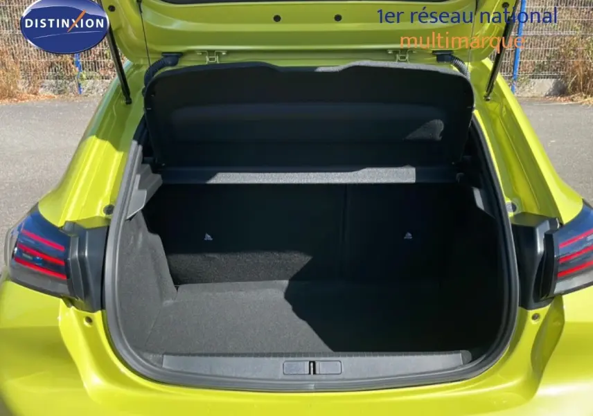 Coffre ouvert vu de l'arrière d'une Peugeot 208 hybride jaune Agueda Metal, avec feux arrière LED visibles.