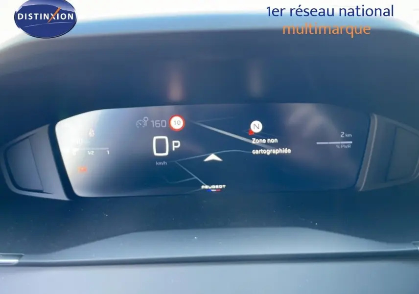 Tableau de bord numérique de la Peugeot 208 Hybrid 110ch, affichant la navigation et la vitesse en mode parking.