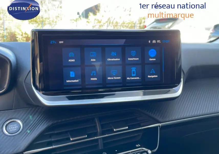 Vue intérieure centrée sur l'écran tactile du tableau de bord de la Peugeot 208 hybride, avec finition carbone et bouton start/stop visible.