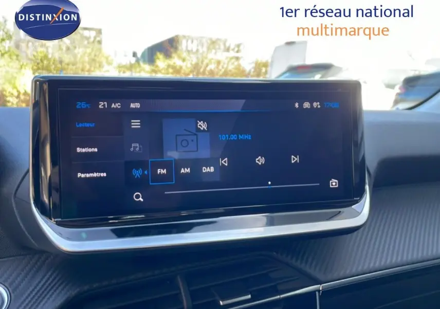 Écran tactile central du tableau de bord d'une Peugeot 208 Hybrid, affichant les options radio FM, AM et DAB.