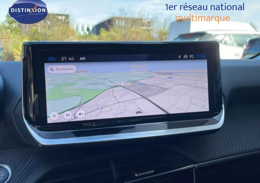 Vue intérieure centrée sur l'écran tactile du système de navigation de la Peugeot 208 hybride, tableau de bord noir.
