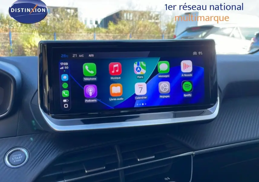 Écran tactile central affichant des applications multimédia dans l’habitacle noir d’une Peugeot 208 hybride.
