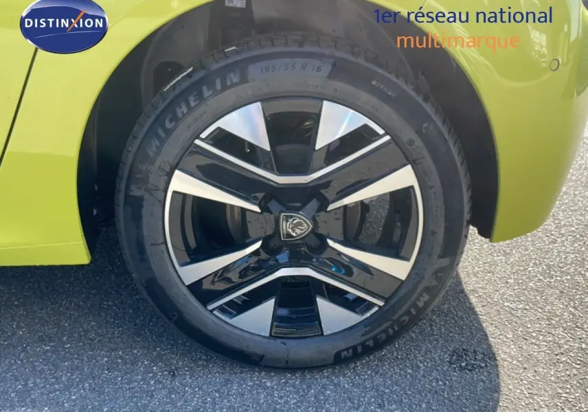 Gros plan sur la roue avant gauche d'une Peugeot 208 jaune Agueda Metal avec jante alliage noire et argentée.