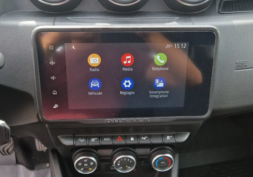 Vue rapprochée de l’écran tactile central et des commandes de climatisation du Dacia Duster 2023, intérieur noir.