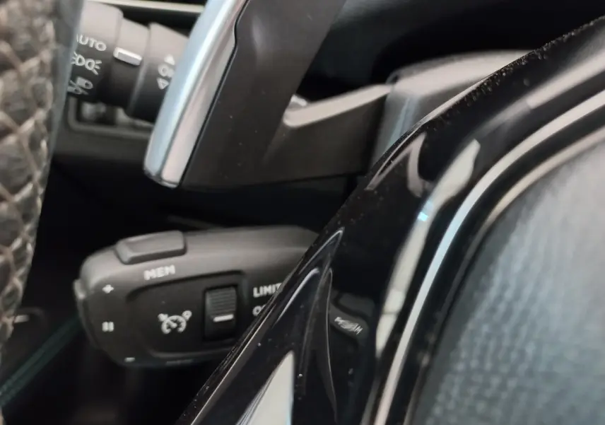 Gros plan sur la commande de régulateur de vitesse à gauche du volant cuir du Peugeot 5008 gris foncé 2021