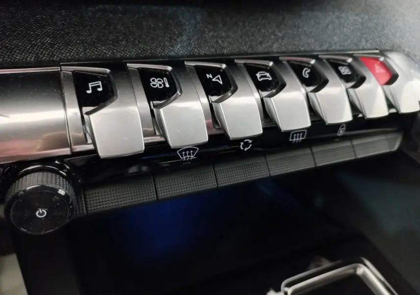 Gros plan sur les commandes chromées du tableau de bord du Peugeot 5008 gris foncé, version Allure Pack 2021.