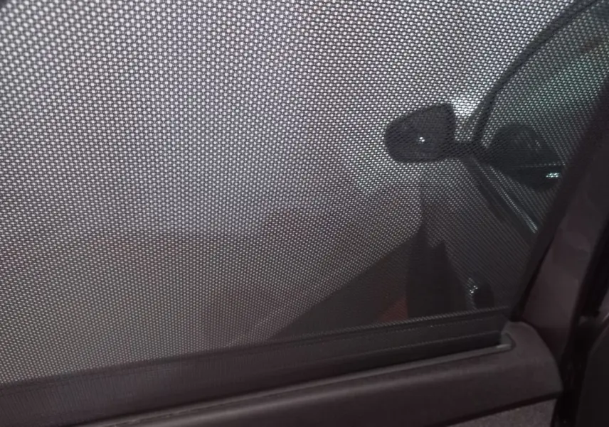 Vue intérieure côté droit du Peugeot 5008 gris foncé 2021 avec store pare-soleil en tissu sur la vitre arrière.