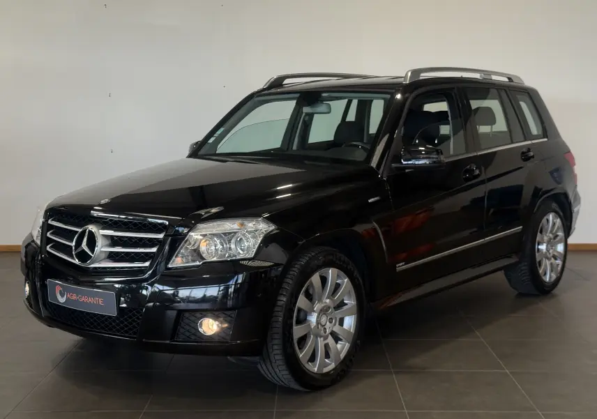 Mercedes GLK 220 CDI noir en 3/4 avant droit, avec jantes alliage et toit ouvrant visible en intérieur showroom.