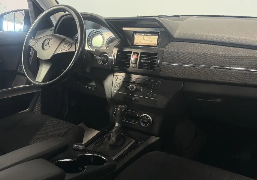 Intérieur noir du Mercedes GLK 220 CDI 2010, vue côté conducteur sur le tableau de bord et la console centrale avec boîte auto.