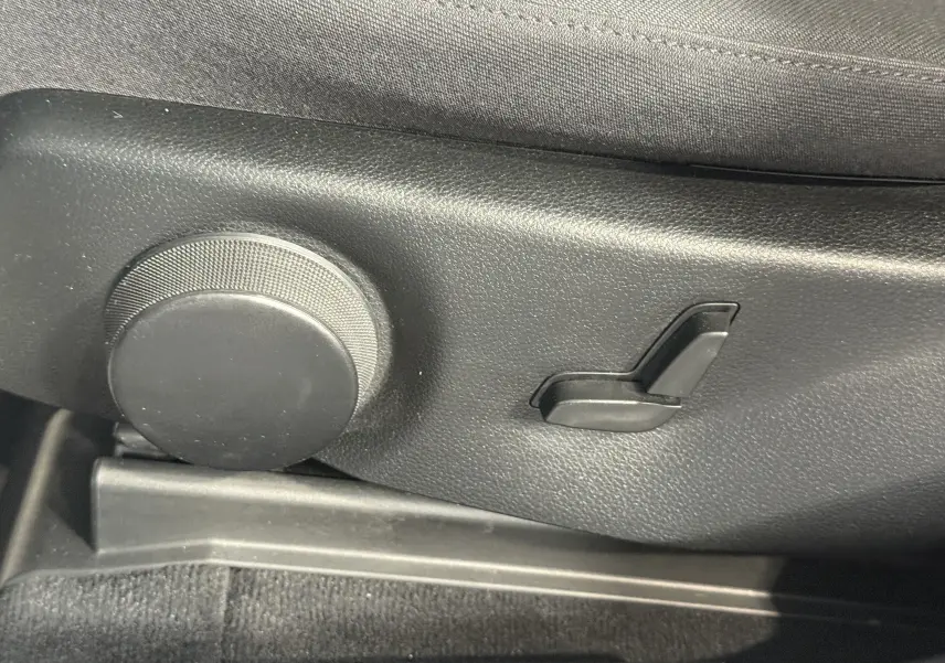 Gros plan sur les commandes de réglage manuel du siège côté conducteur du Mercedes GLK 220 cdi noir de 2010.