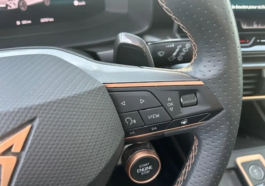 Gros plan sur le volant cuir perforé côté droit du CUPRA Formentor blanc neige avec bouton Start Engine Stop visible.